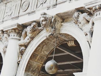 Low angle view of statue against historic building