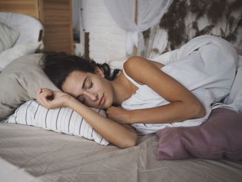 Young woman sleeping on bed