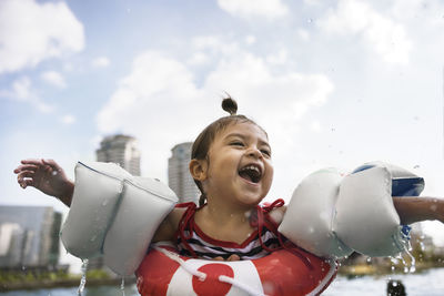 Smiling girl with swimming armbands in swimming pool