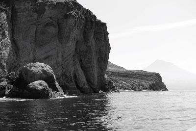 Rock formation in sea against sky