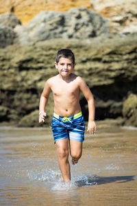 Little kid running on a rocky beach
