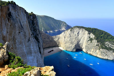 Scenic view of sea and mountains against blue sky