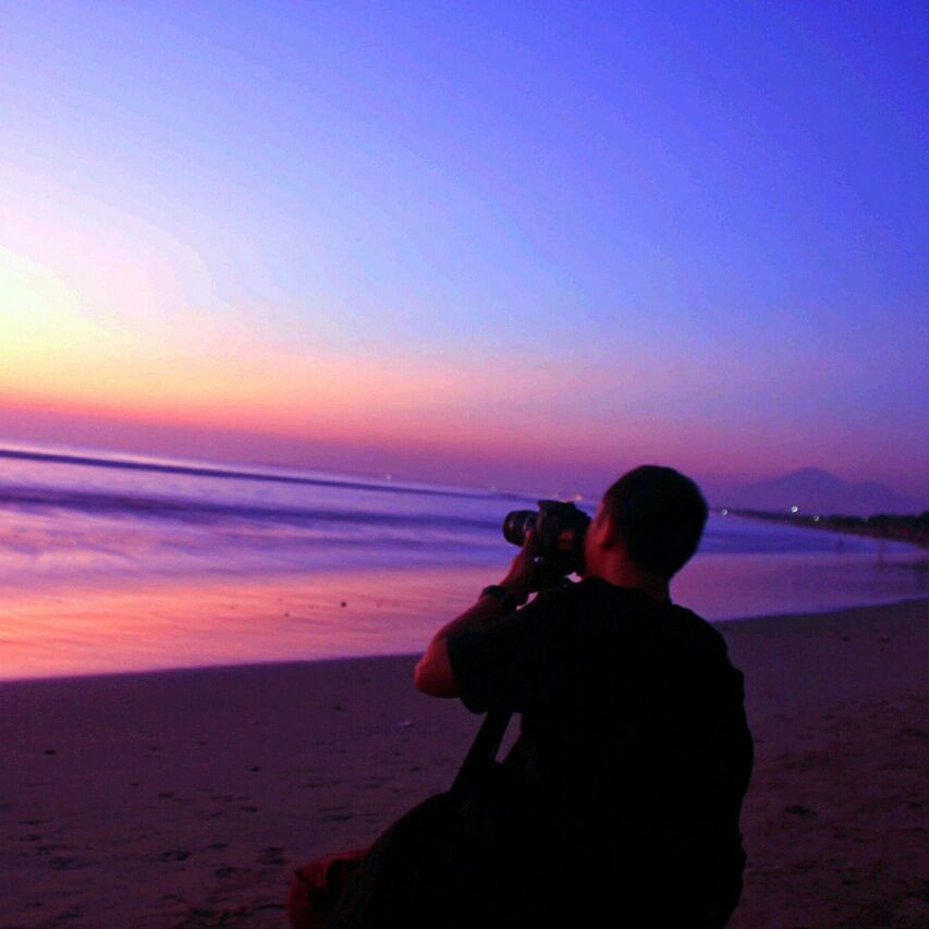 sea, sunset, water, horizon over water, lifestyles, leisure activity, beach, scenics, sky, men, silhouette, tranquil scene, tranquility, beauty in nature, standing, shore, rear view, copy space