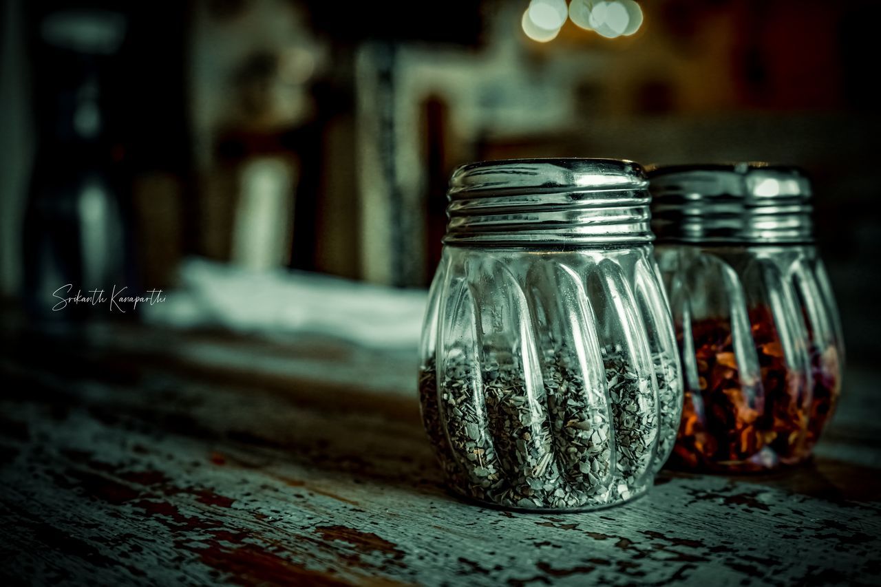 CLOSE-UP OF GLASS OF JAR ON TABLE