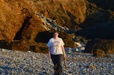 Portrait of young man standing on rock