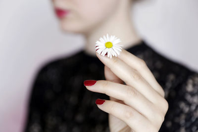 Midsection of woman holding pink flowering plant