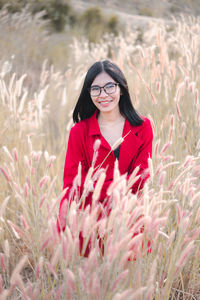 Portrait of smiling young woman standing on field