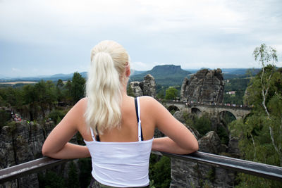 Rear view of teenage girl standing against mountain