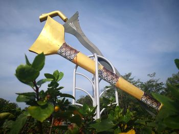 Low angle view of yellow metal structure against sky