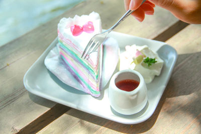 Midsection of person holding ice cream on table