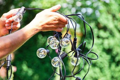 Cropped hands holding lighting equipment