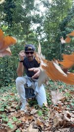 Portrait of smiling man holding leaves during autumn