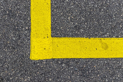 High angle view of yellow arrow symbol on road