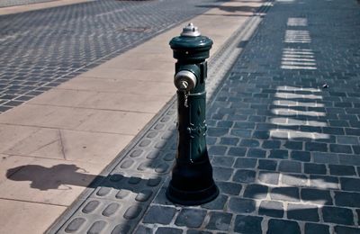 Fire hydrant at sidewalk in city