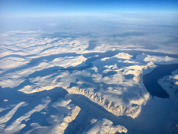Aerial view of snowcapped landscape against sky