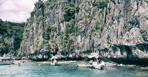 Group of people on rock by sea