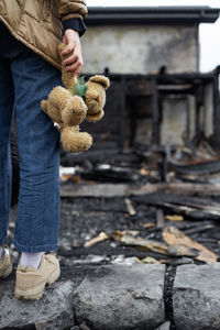 A girl next to a house destroyed by the war. war in ukraine. child in the ruins