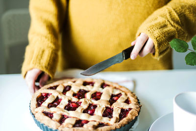 Midsection of woman holding ice cream on table