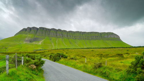 Road amidst green landscape against sky