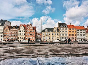 Buildings in city against sky during winter