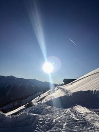 Scenic view of snowcapped mountains against sky on sunny day