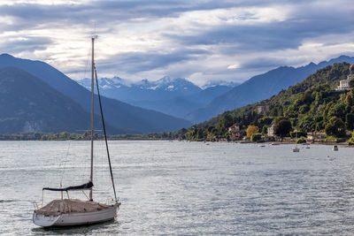 Sailboats in sea against mountains