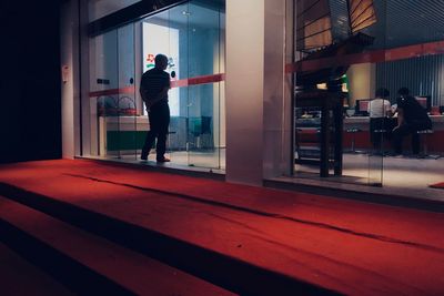 Rear view of man standing at entrance of building