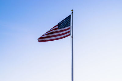 Low angle view of flag against clear blue sky