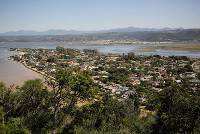 High angle view of townscape by sea against sky