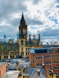 Buildings in city against cloudy sky