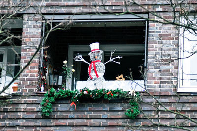 Low angle view of snowman decoration on window