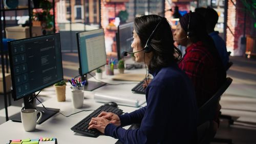 Rear view of people working at office