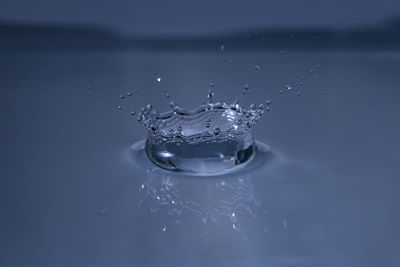 Close-up of splashing water drop hitting water surface