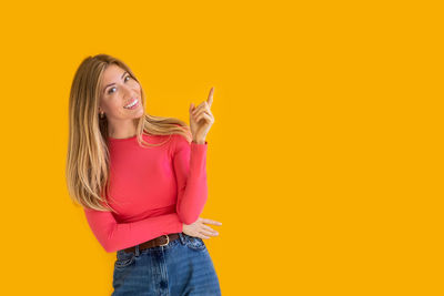 Portrait of young woman against yellow background