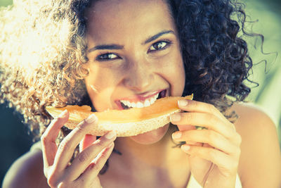 Close-up portrait of woman eating fruit