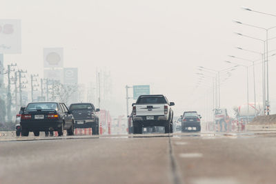 Traffic on road in city against sky