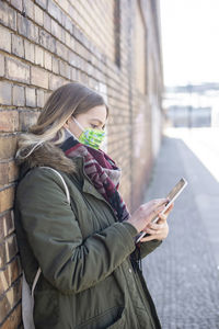 Midsection of man using mobile phone in winter