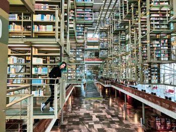 Low angle view of man reading book on staircase in building