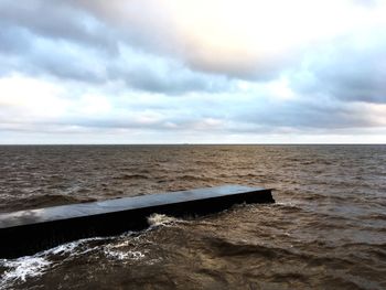 View of calm sea against cloudy sky