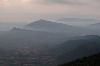Scenic view of mountains against cloudy sky