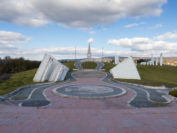 Empty footpath in park against sky