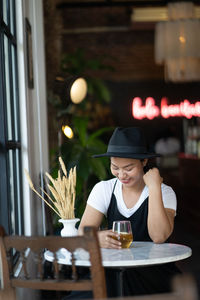 Midsection of woman holding drink in restaurant