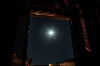 Low angle view of illuminated lights against sky at night