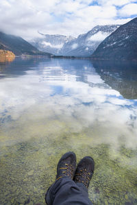 Low section of man at hallstatter lake against sky