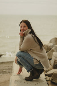 Portrait of young woman standing at beach