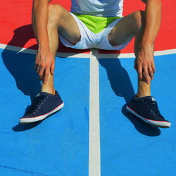 Low section of athlete sitting on field
