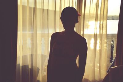 Close-up of woman standing against white wall