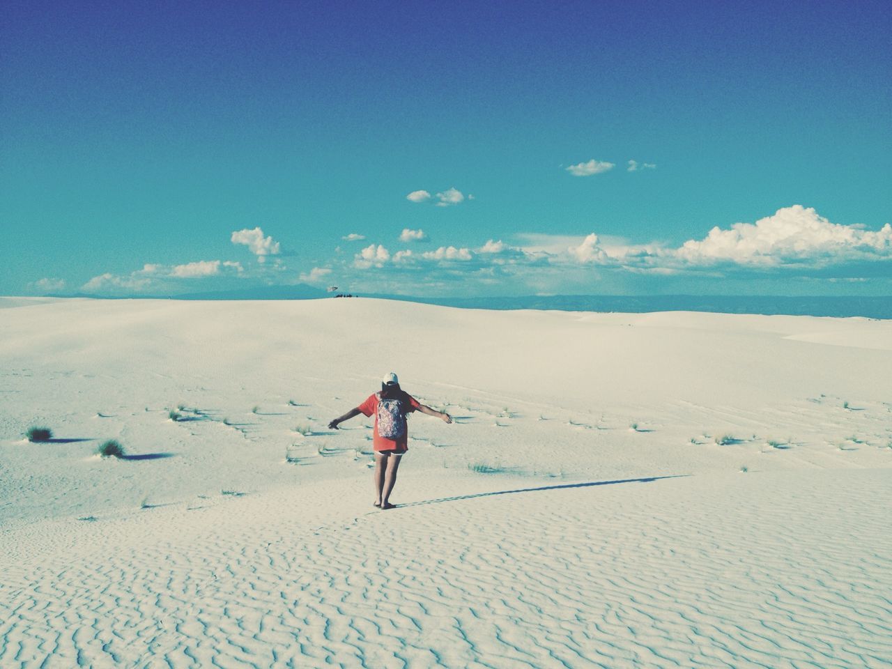 snow, winter, cold temperature, leisure activity, full length, landscape, lifestyles, tranquil scene, season, tranquility, sky, blue, sand, walking, scenics, nature, beauty in nature, vacations