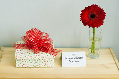 Red flower in box on table