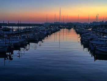 Boats in sea at sunset